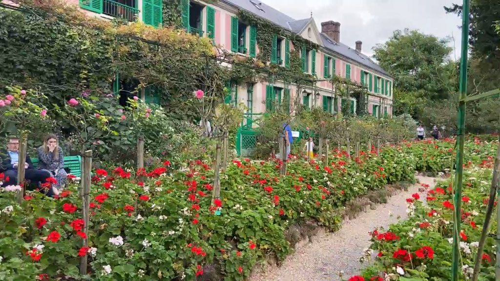 people enjoying the red flowers near Claude Monet's house